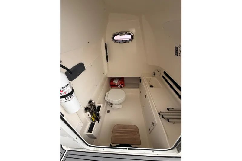Slide: The Image of Interior of 2018 Boston Whaler 330 Outrage boat, featuring a compact bathroom with essential amenities. - 21