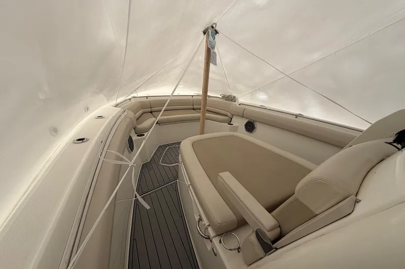 Slide: The Image of 2018 Boston Whaler 330 Outrage interior with cushioned seating and covered deck. - 24