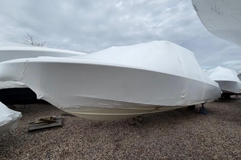 Slide: The Image of 2018 Boston Whaler 330 Outrage boat covered in protective wrap on gravel. - 26