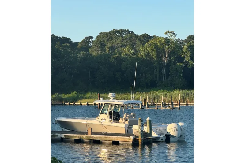 Slide: The Image of 2018 Boston Whaler 330 Outrage docked by a serene, wooded shoreline. - 4