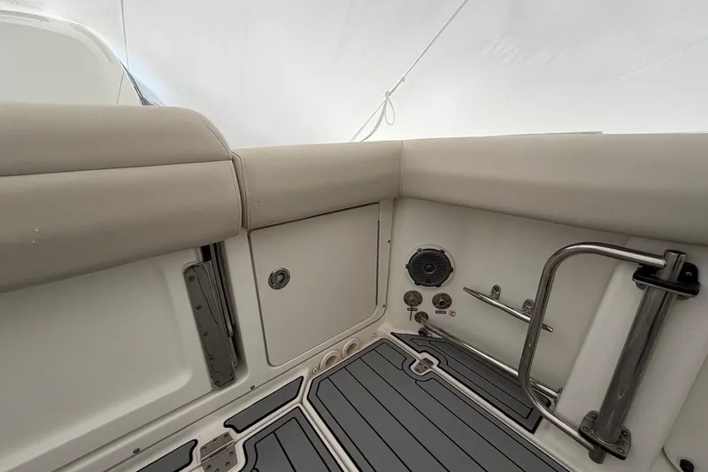 Slide: The Image of Interior view of a 2018 Boston Whaler 330 Outrage boat, featuring cushioned seating and stainless steel fixtures. - 8