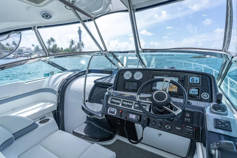 Slide: The Image of 2022 Formula 40 PC yacht cockpit with modern navigation system, steering wheel, and ocean view. - 13