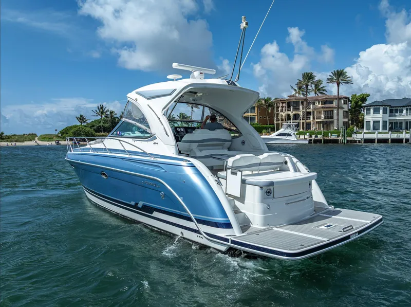 Slide: The Image of 2022 Formula 40 PC yacht cruising on a sunny day near luxury waterfront homes. - 2