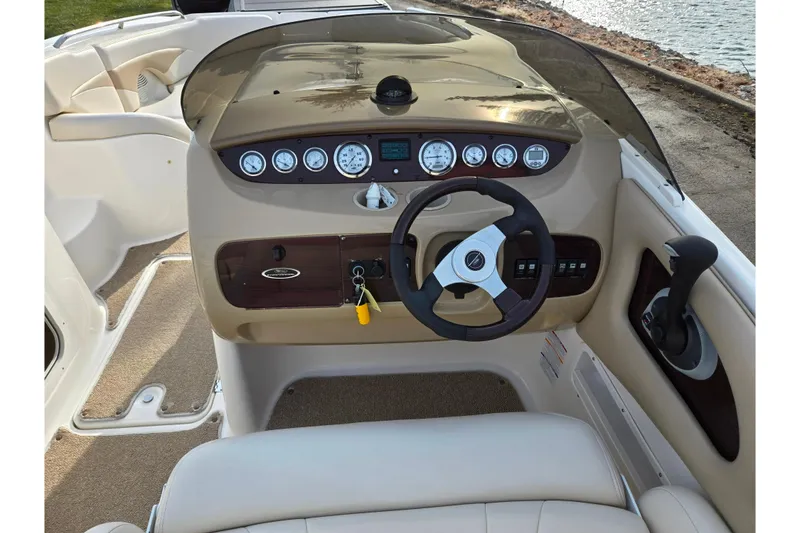 Slide: The Image of 2002 Chaparral Sunesta 242 boat dashboard with steering wheel and control panel. - 11