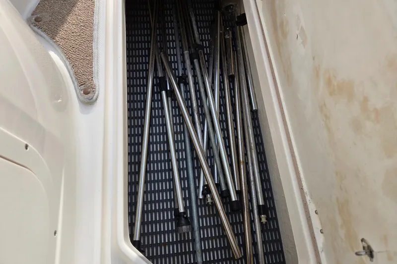 Slide: The Image of Storage compartment with metal poles in a 2002 Chaparral Sunesta 242 boat. - 15