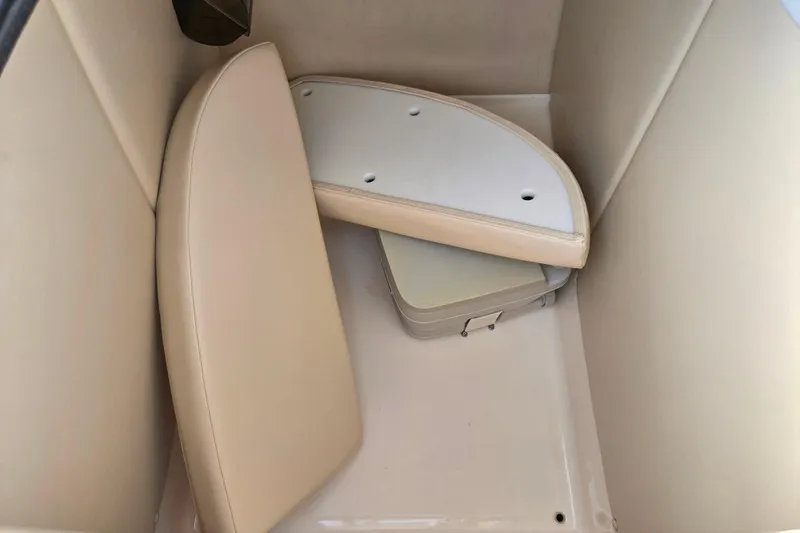 Slide: The Image of 2002 Chaparral Sunesta 242 boat interior with beige cushions and storage compartment. - 16