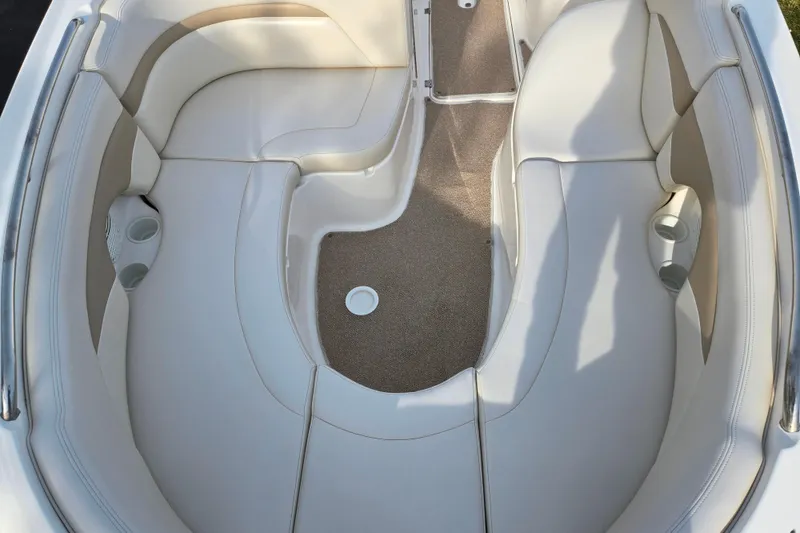 Slide: The Image of 2002 Chaparral Sunesta 242 boat interior with beige seating and cup holders. - 19