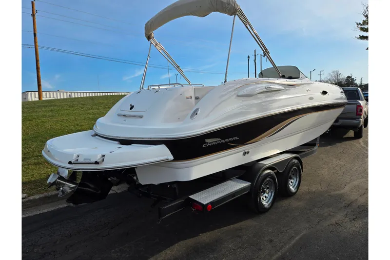 Slide: The Image of 2002 Chaparral Sunesta 242 boat on trailer, white with black accents, parked outdoors. - 3