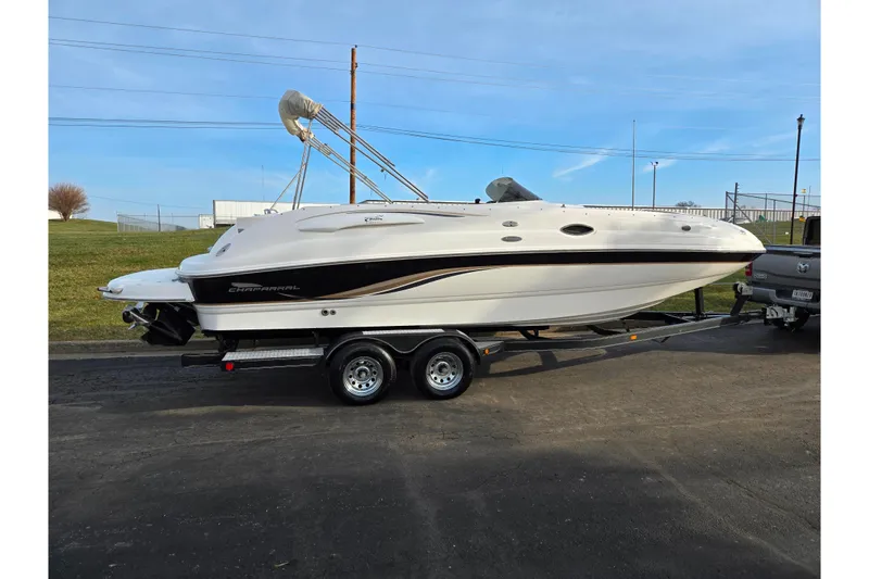 Slide: The Image of 2002 Chaparral Sunesta 242 boat on trailer, parked outdoors under clear blue sky. - 4
