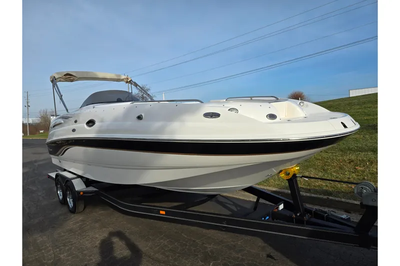 Slide: The Image of 2002 Chaparral Sunesta 242 boat on trailer, parked outdoors under clear sky. - 5