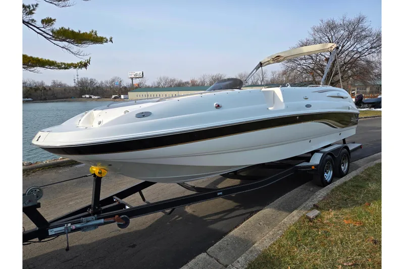 Slide: The Image of 2002 Chaparral Sunesta 242 boat on trailer by a lakeside road. - 8