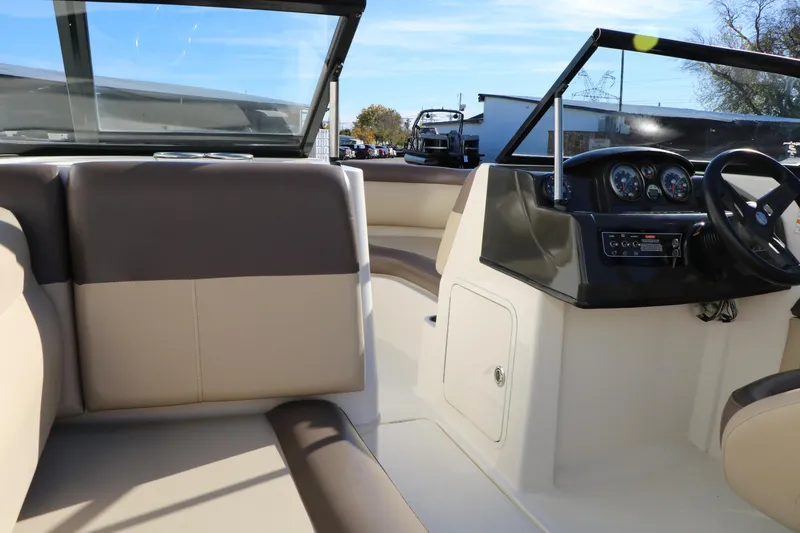 Slide: The Image of 2017 Bayliner 195 Deck Boat interior with beige seating and steering console. - 18
