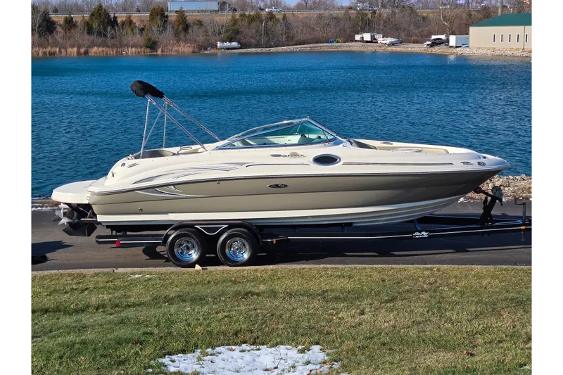 The Image of 2005 Sea Ray 240 Sundeck boat on trailer by a lake. - 0