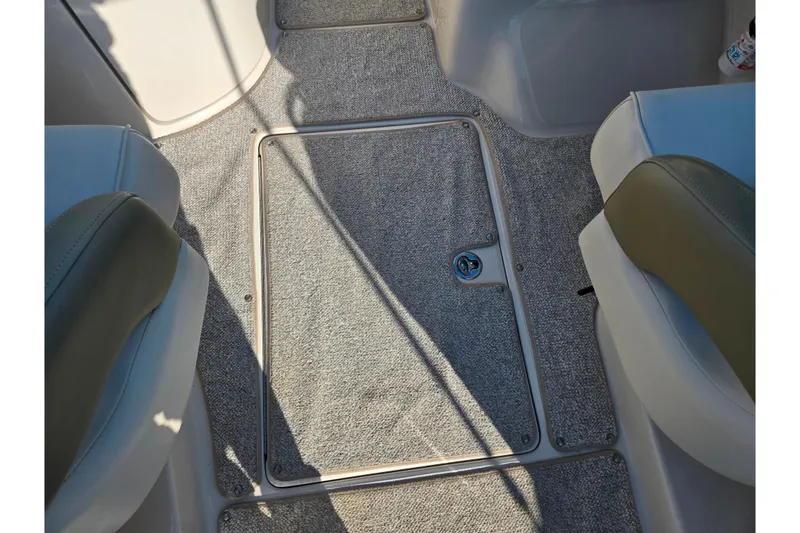 Slide: The Image of 2005 Sea Ray 240 Sundeck interior with carpeted flooring and seating. - 11