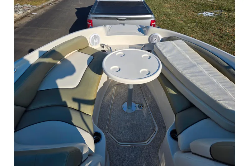 Slide: The Image of 2005 Sea Ray 240 Sundeck interior with seating and table, parked on a trailer. - 17