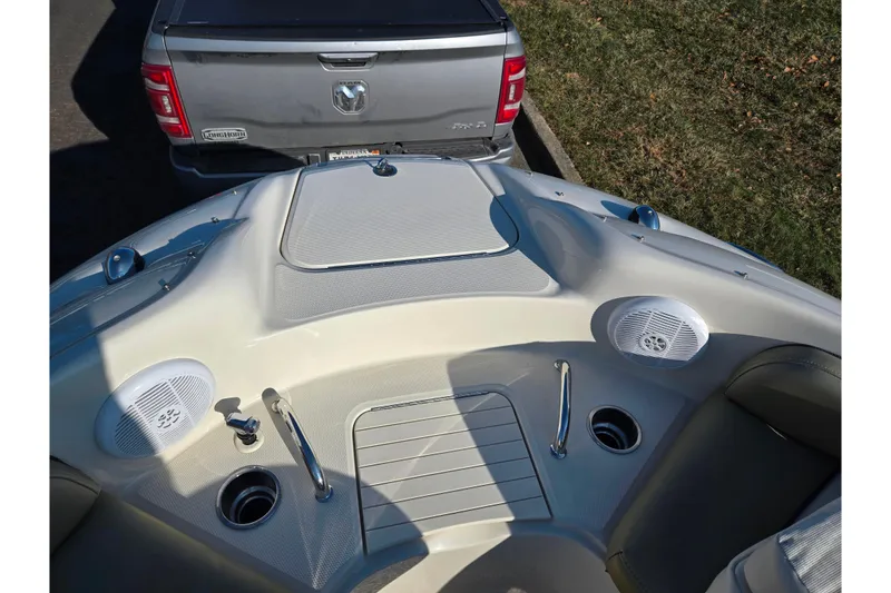Slide: The Image of 2005 Sea Ray 240 Sundeck boat interior with speakers, cup holders, and a truck in the background. - 18