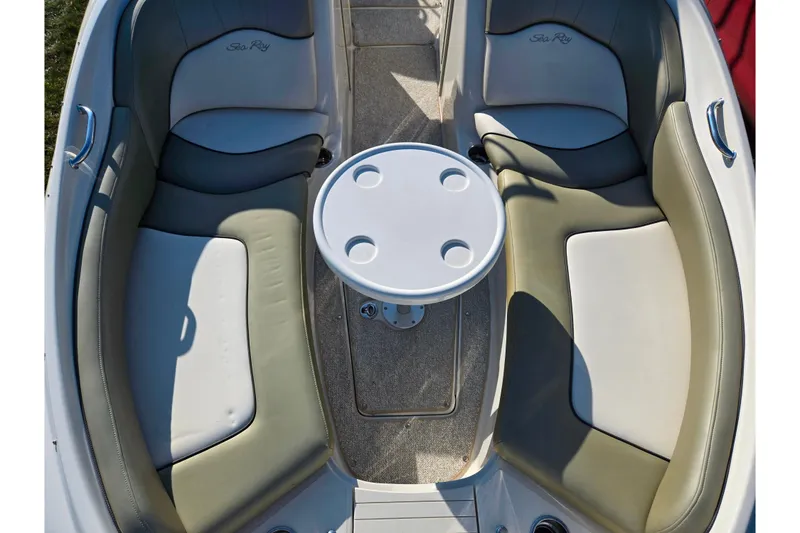 Slide: The Image of 2005 Sea Ray 240 Sundeck interior with seating and round table. - 19