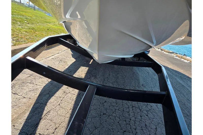 Slide: The Image of 2005 Sea Ray 240 Sundeck on trailer, parked on cracked pavement near water. - 7