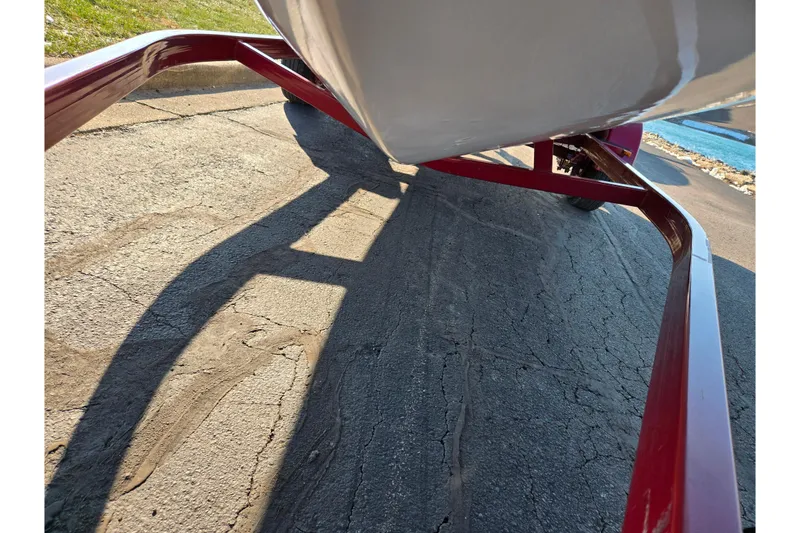 Slide: The Image of Red trailer holding a 2007 Glastron GT 205 Ski & Fish boat on a paved surface. - 8