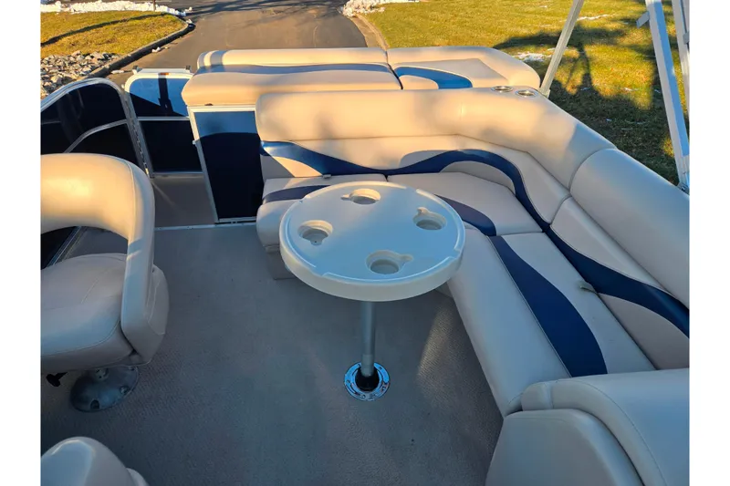Slide: The Image of 2012 Berkshire 190CL LSR pontoon boat interior with beige seating and table. - 13
