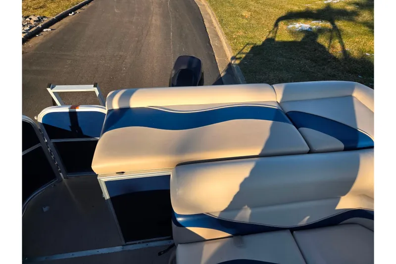 Slide: The Image of 2012 Berkshire 190CL LSR boat with beige and blue seating, parked on a paved road. - 14