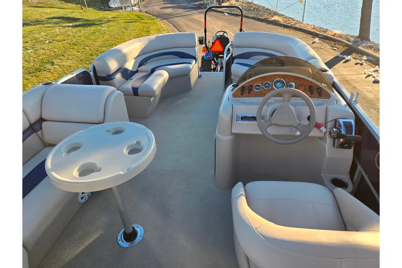 Slide: The Image of 2012 Berkshire 190CL LSR pontoon boat interior with plush seating and steering console. - 18