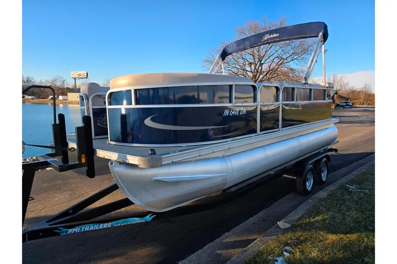 Slide: The Image of 2012 Berkshire 190CL LSR pontoon boat on trailer by a lake. - 8