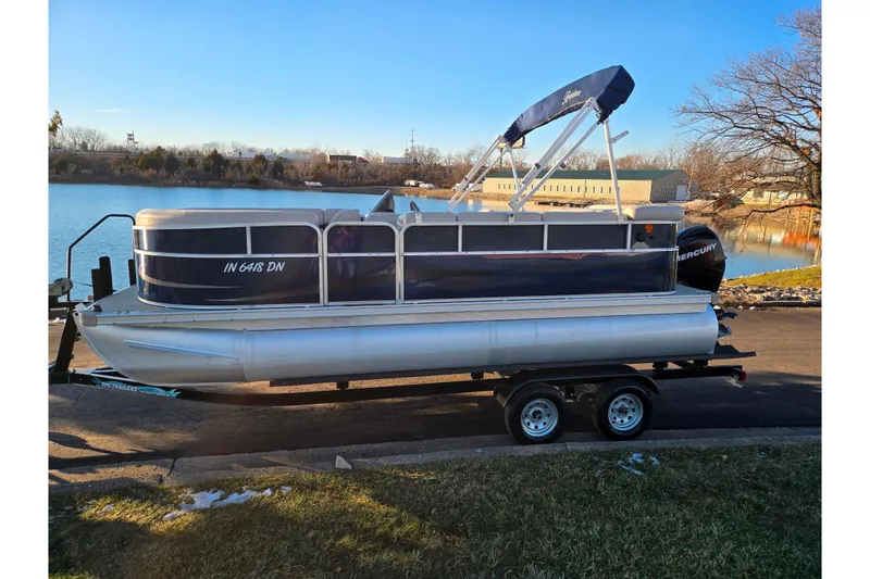 Slide: The Image of 2012 Berkshire 190CL LSR pontoon boat on trailer by a lake. - 9