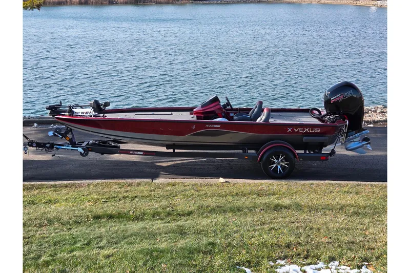 The Image of 2019 Vexus AVX1980 boat on trailer by a lake, showcasing sleek design and powerful engine. - 0