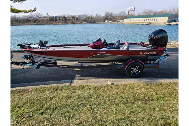 Slide: The Image of 2019 Vexus AVX1980 boat on trailer by a lake, featuring sleek red design. - 11