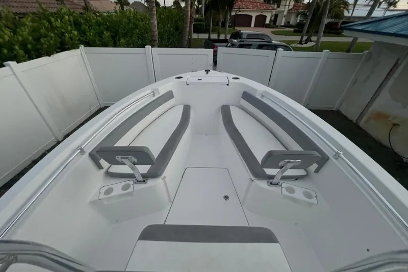 Slide: The Image of 2019 Release 208RX boat on trailer at dealership under sunny sky. - 10