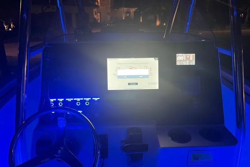 Slide: The Image of 2019 Release 208RX boat interior at dealership, featuring console and rod holders. - 18