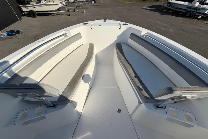 Slide: The Image of Bow seating area of a 2019 Release 208RX boat, featuring cushioned benches and cup holders. - 37