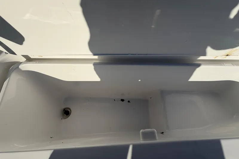 Slide: The Image of Open storage compartment of 2019 Release 208RX boat, showing interior space and drain. - 41