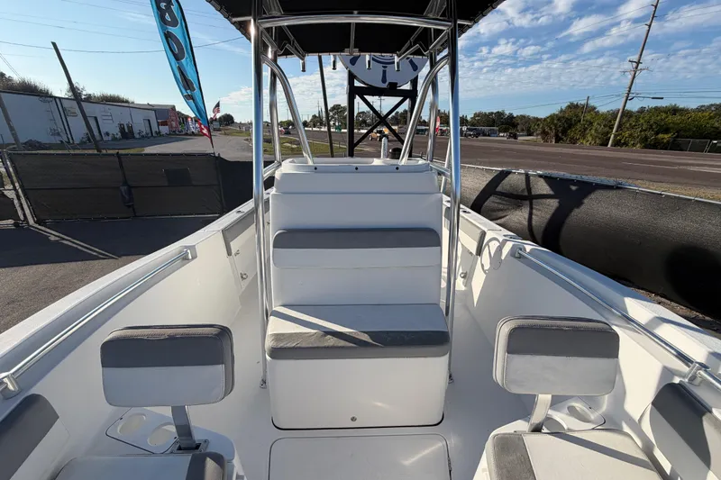 Slide: The Image of 2019 Release 208RX boat interior with seating and console, parked outdoors. - 49