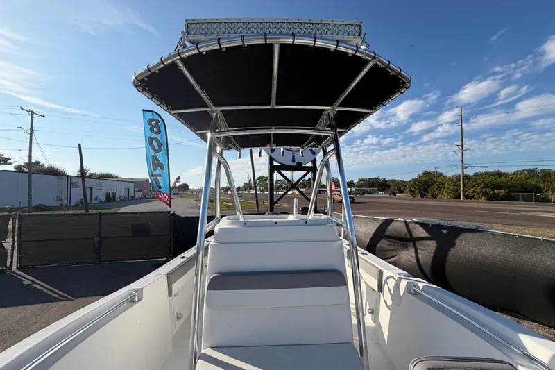 Slide: The Image of 2019 Release 208RX boat with T-top canopy, parked near a road under a clear sky. - 50