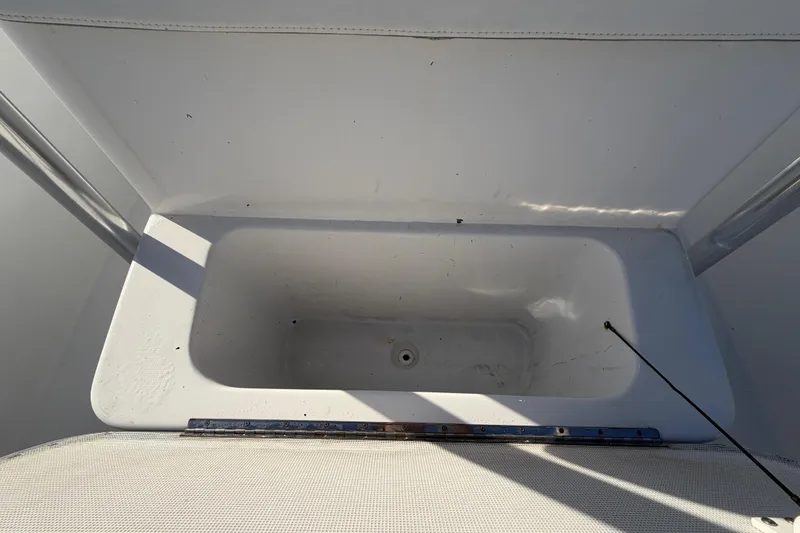 Slide: The Image of Empty storage compartment on a 2019 Release 208RX boat, featuring a clean white interior. - 52