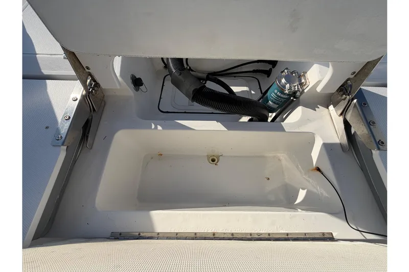 Slide: The Image of Open storage compartment in 2019 Release 208RX boat, showing internal components and wiring. - 62