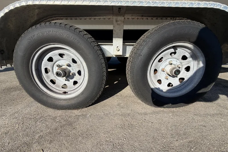 Slide: The Image of Dual wheels of a 2019 Release 208RX trailer on asphalt surface. - 69