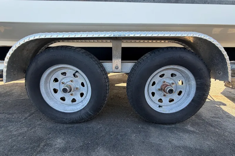 Slide: The Image of Dual wheels on a 2019 Release 208RX trailer, parked on asphalt. - 70