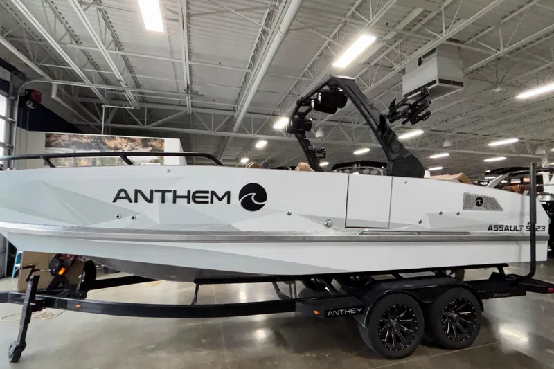 Slide: The Image of 2026 Anthem Assault ST23 boat in showroom, sleek design, white exterior, on trailer. - 1