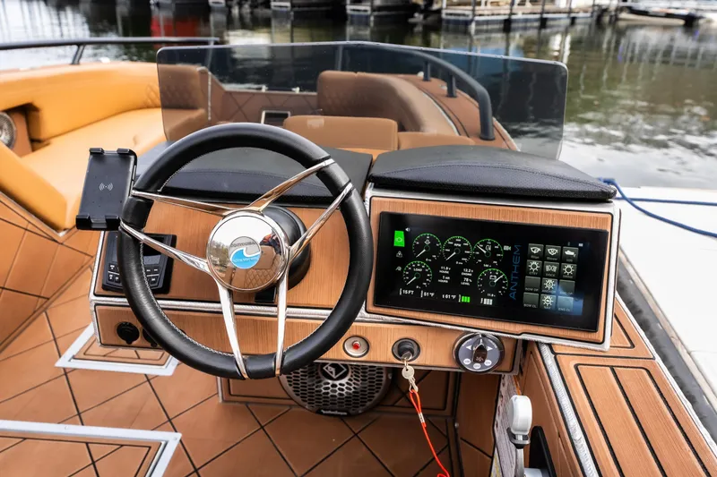 Slide: The Image of Steering wheel and dashboard of 2026 Anthem Assault ST23 boat, featuring modern controls. - 19