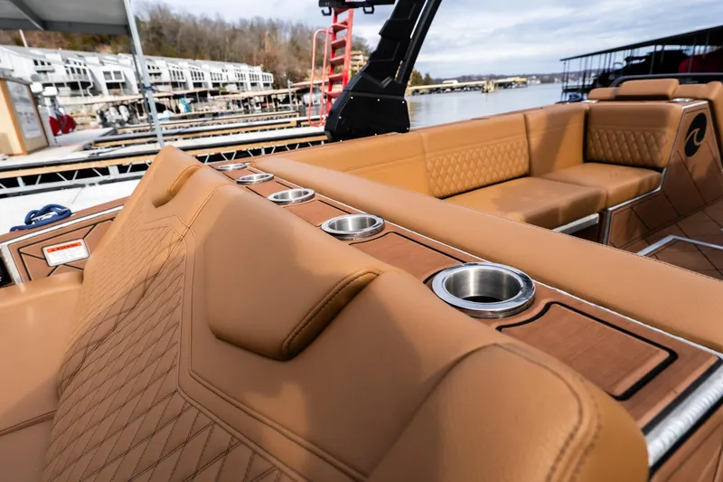 Slide: The Image of Luxurious seating on 2026 Anthem Assault ST23 boat with cup holders, dockside view. - 21