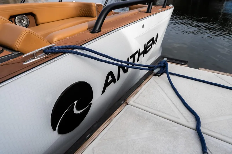 Slide: The Image of 2026 Anthem Assault ST23 boat docked with blue rope, featuring tan seating. - 27