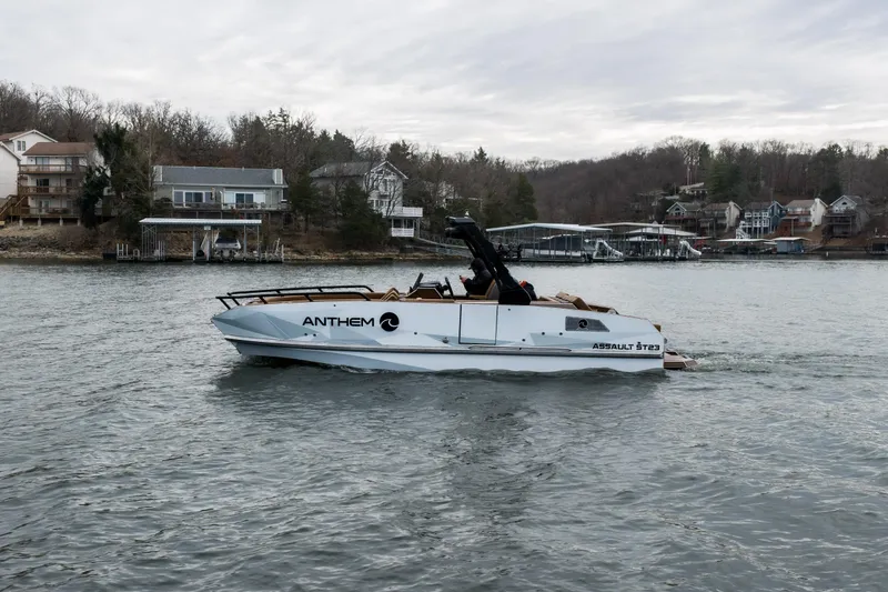Slide: The Image of 2026 Anthem Assault ST23 boat cruising on a lake with houses in the background. - 33