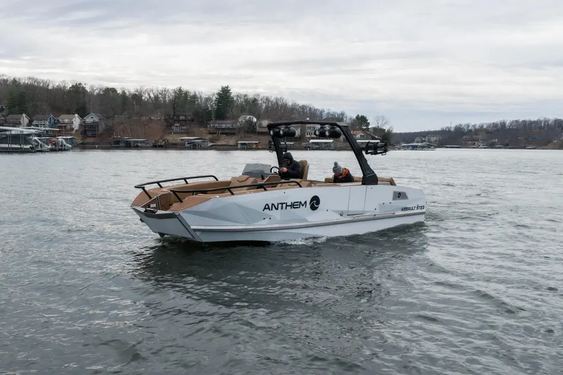 Slide: The Image of 2026 Anthem Assault ST23 boat cruising on a lake with scenic shoreline background. - 34