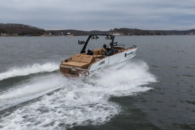 Slide: The Image of 2026 Anthem Assault ST23 boat cruising on a lake with wake trails. - 38