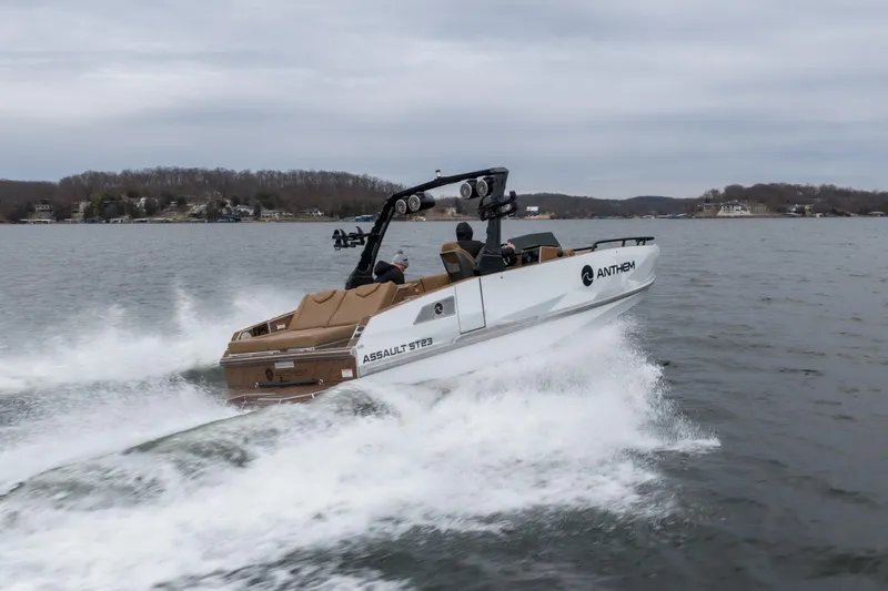 Slide: The Image of 2026 Anthem Assault ST23 speedboat cruising on a lake with scenic shoreline. - 39