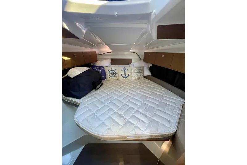 Slide: The Image of Cozy cabin interior of 2020 Beneteau Antares 9 with nautical-themed pillows. - 11
