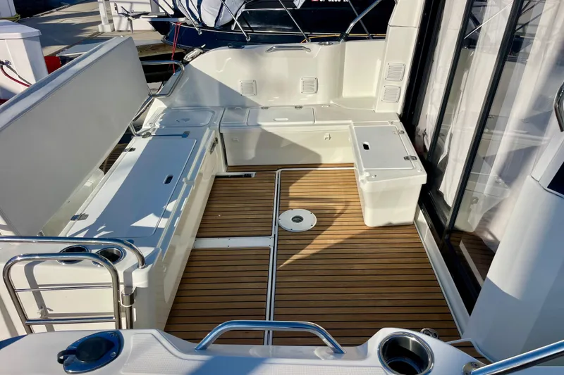 Slide: The Image of 2020 Beneteau Antares 9 boat deck with teak flooring and seating area. - 15